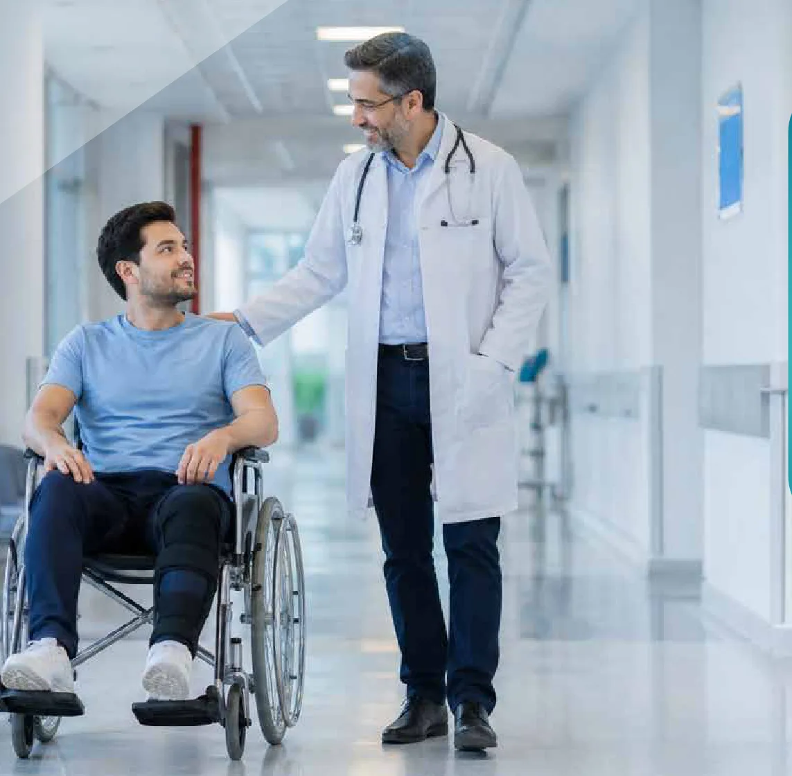 Médico acompañando a un paciente en silla de ruedas por el pasillo de una clínica