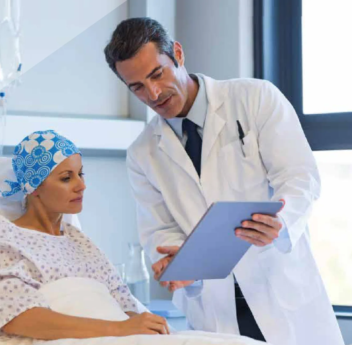 Médico conversando con una paciente oncológica en una habitación de hospital